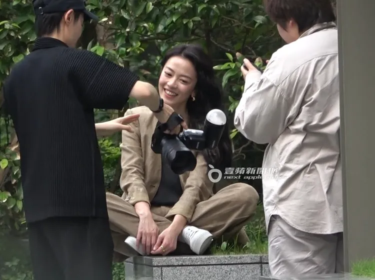 喻虹淵（中）檢查拍攝畫面，笑容燦爛。特勤中心攝