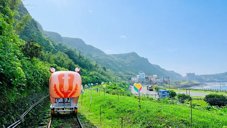 旅客搭乘深澳鐵道自行車特製的螃蟹造型車依山傍海前行，沿途不僅能飽覽新北北海岸的翠綠山巒，更能將開闊的海景盡收眼底。觀光局提供