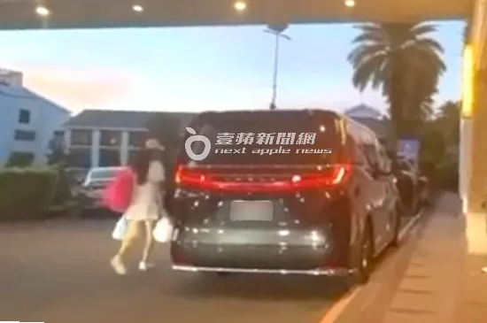2025/7/30傍晚，謝女肩背紅色包包，手拿白色袋子，快步從郭台銘左側車門上車。特勤中心攝