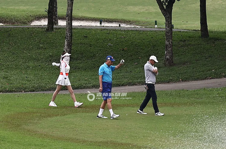 2026/4/11下午，郭台銘（中）與謝女（左）及球友在草皮上散步做熱身操。特勤中心攝