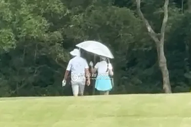 2025/7/30下午，謝女（右）貼心幫郭台銘撐傘遮陽獻殷勤。特勤中心攝