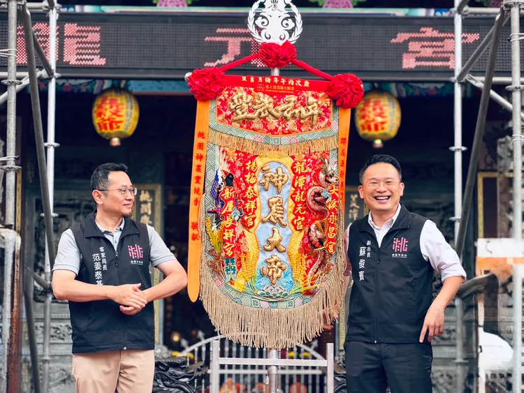 蘇俊賓表示，龍元宮不斷將信仰文化創新呈現，今年首次融合桃園埤塘水文特色，以及代表生態多樣性的台灣藍鵲與赤腹游蛇等在地物種，創作出兼具文化與保育意涵的輪值頭旗。客家局提供
