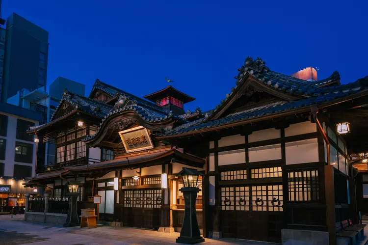 道後溫泉本館夜間點燈，振鷺閣透紅光。本丸酒業提供