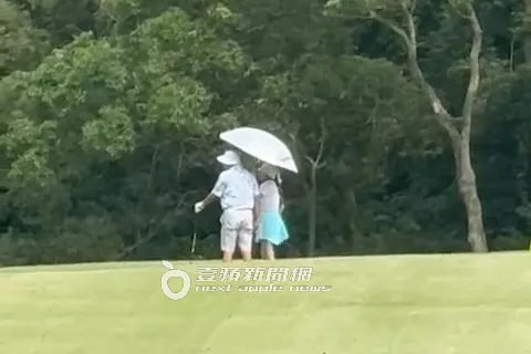 2025/7/30，謝女（右）刻意靠著郭董替她撐傘獻殷勤。特勤中心攝