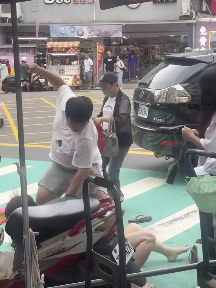 駕駛方的白衣男疑因不滿對方踢了小孩一腳，把黑衣女摔倒在地出拳毆打。Threads/round2_ricky提供
