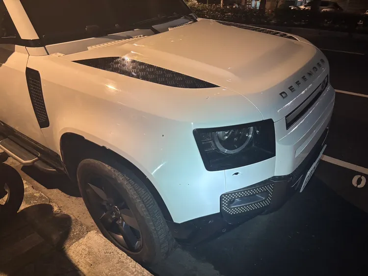 一輛停放路旁的白色小客車遭波及受損。翻攝畫面