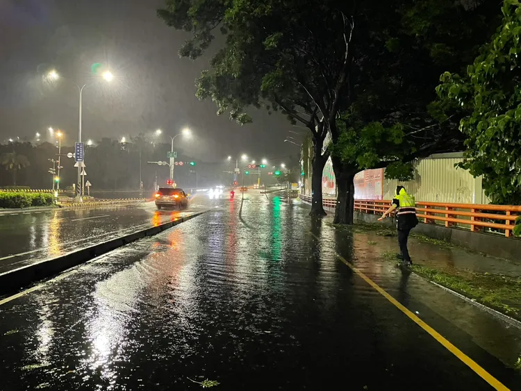警方說，該路段慢車道當時積水嚴重，員警擔心影響行車安全才徒手清除排水口雜物。民眾提供