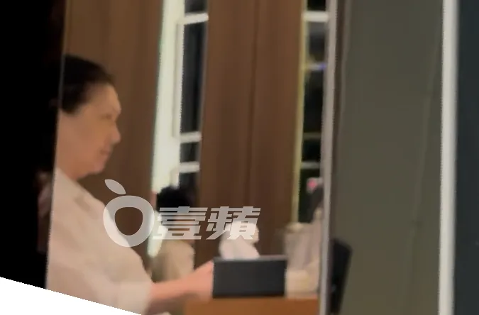 S媽穿著白色上衣，聽著孫女們聊天。特勤中心攝