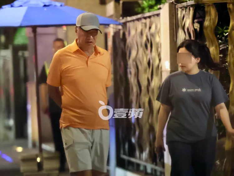 6月29日，郭台銘（左）表情嚴肅和工作人員在「信義富邦」舊家附近散步。特勤中心攝