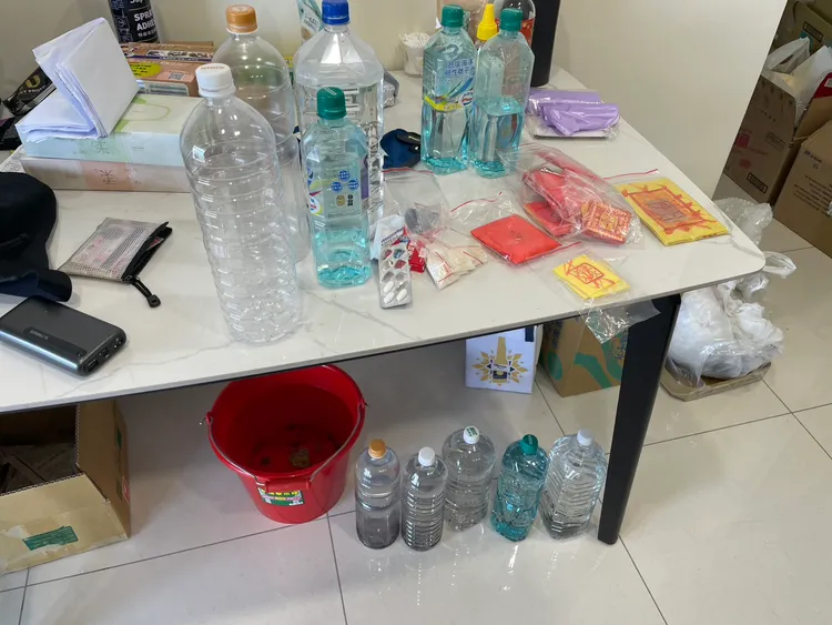 犯嫌在屋內貼符紙、喝福水求財求平安。民眾提供