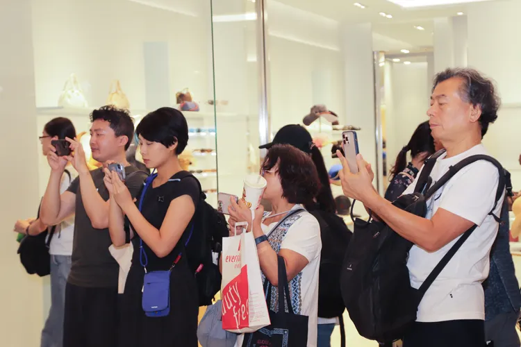 文山國小直笛團精彩演出吸引許多旅客停下腳步拍照、錄影留念，讓旅客感受臺灣學童的藝術能量。昇恆昌免稅商店提供