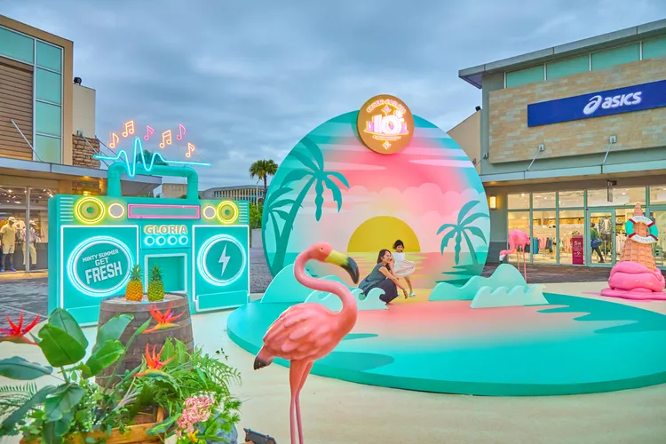 三期廣場「Minty Summer Stage」暖色餘暉從背板一路延伸至地面，打造最迷人的海岸日落舞台。業者提供