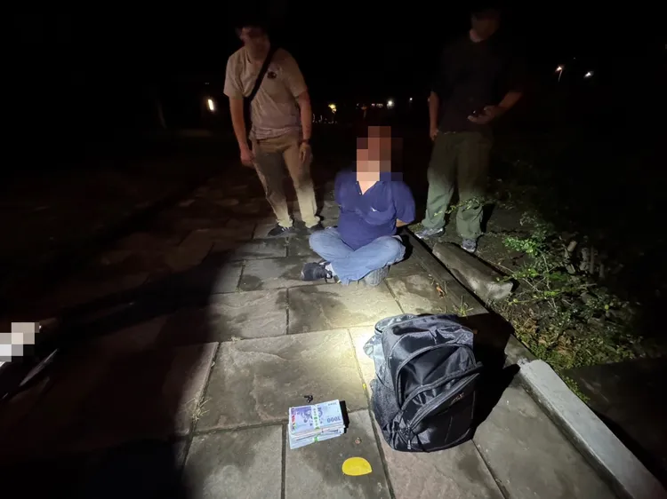 警方在左營區原生植物園前逮捕面交車手王男，並查扣新臺幣50萬元。翻攝畫面