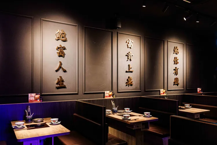店內以深色簡約設計為概念，凸顯金黃鮑魚雞湯的美味。業者提供