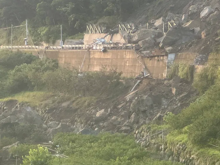 小貨車路過遭落石推擠，幸好被護欄擋住。翻攝畫面