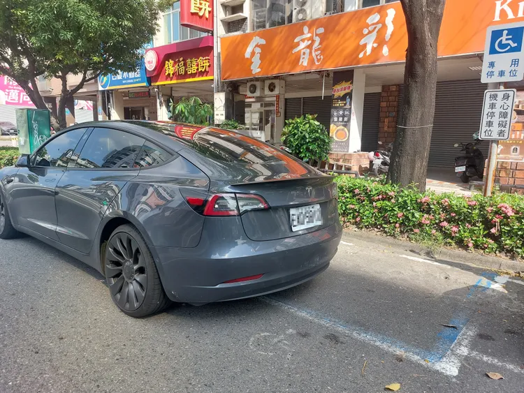 1部汽車壓住部分殘障機車格位。凃建豐攝
