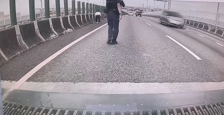 警方在國道路肩警示，協助女駕駛找回手機。民眾提供