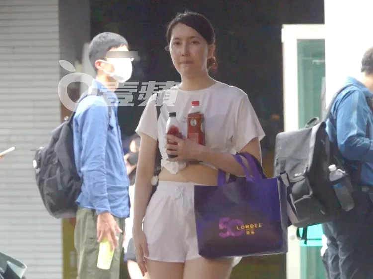 陳匡怡將飲料抱在胸前，等待計程車抵達。特勤中心攝