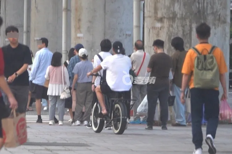 王柏傑騎著電輔車穿梭在等待過馬路的人群中。特勤中心攝