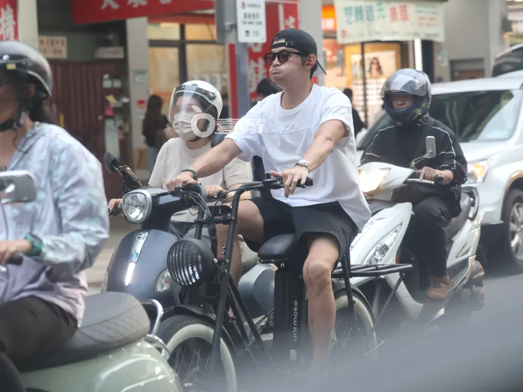 王柏傑騎電輔車停在車陣中，臉上不時鼓氣，似乎有些等不及。特勤中心攝