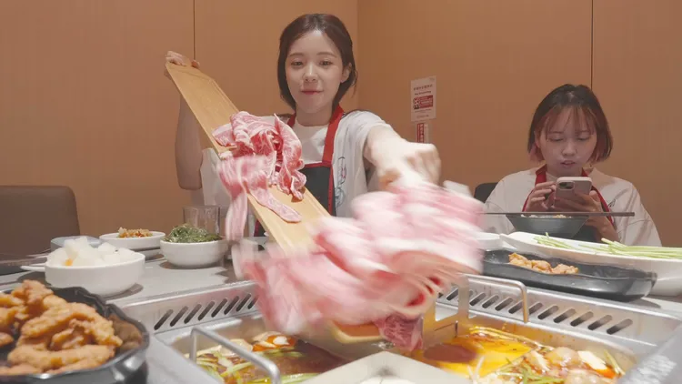 李多慧與團隊夥伴慶功宴上豪邁下肉。翻攝自李多慧YouTube