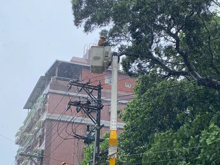 巴威颱風挾帶強風豪雨，造成多地停電，台電人員於新北市五股區冒雨搶修。台電提供