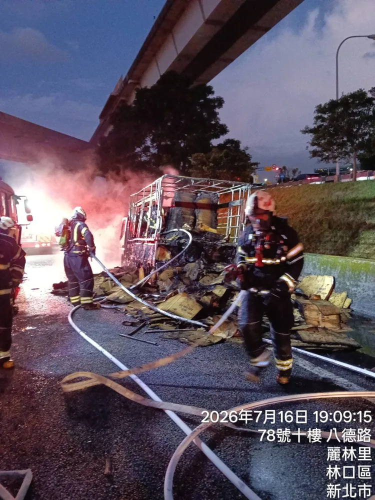 小貨車後方紙箱類貨物突然冒煙起火，隨即延燒到整輛車，駕駛棄車逃生，消防人員緊急滅火。翻攝畫面