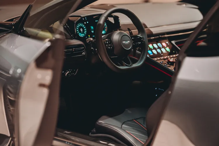 Aston Martin DB12 S座艙中控台採用金屬飾板與高質感皮革鋪陳，中央配置駕駛模式旋鈕及多項車輛控制介面，搭配紅色細節與S專屬元素，營造兼具豪華質感與性能氛圍的座艙。業者提供