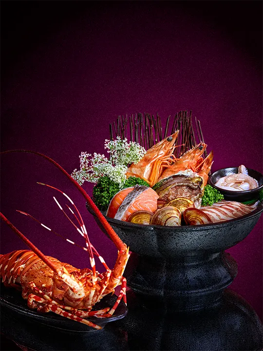 橘色涮涮屋七夕雙人海陸饗宴中包含活龍蝦與南非活鮑魚、鮭魚、九孔、軟絲等豐富海鮮盛合，煮出一鍋清甜鮮味。業者提供