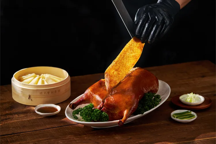 烤鴨一出爐先片下胸脯部位最完整的酥皮，建議趁熱先將鴨皮蘸白糖享用，是老饕最愛的吃法。業者提供