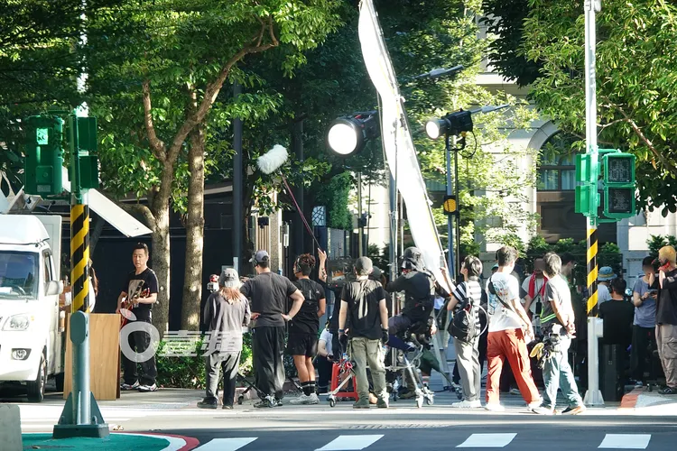 庾澄慶（左）站在餐車旁彈電吉他本色演出，一旁工作人員大陣仗封街拍攝。特勤中心攝