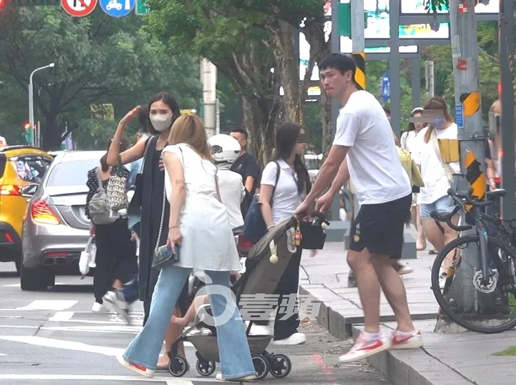 過馬路時，劉雨柔回頭幫忙提嬰兒車，夫妻分工默契十足。特勤中心攝