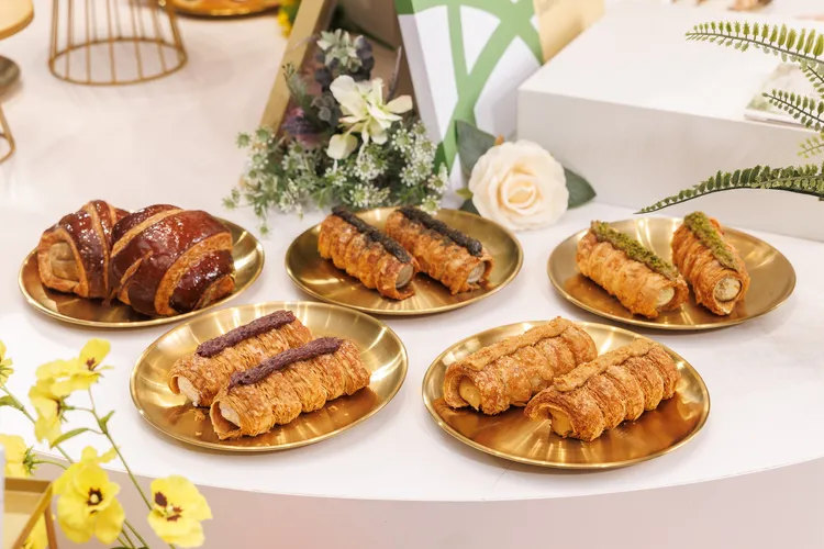 本次新品焦點「杜拜金絲丹麥捲」系列，推出「翡翠開心果」、「醇香厚花生」、「濃焙黑芝麻」與「薰衣草藍莓」等 4 種豐富口味，以酥香丹麥層次結合杜拜金絲口感；「烤地瓜丹麥」則將地瓜的自然香甜融入酥香丹麥麵包，透過植優烘焙用油細緻堆疊口感，為熟悉的經典風味帶來創意詮釋。業者提供