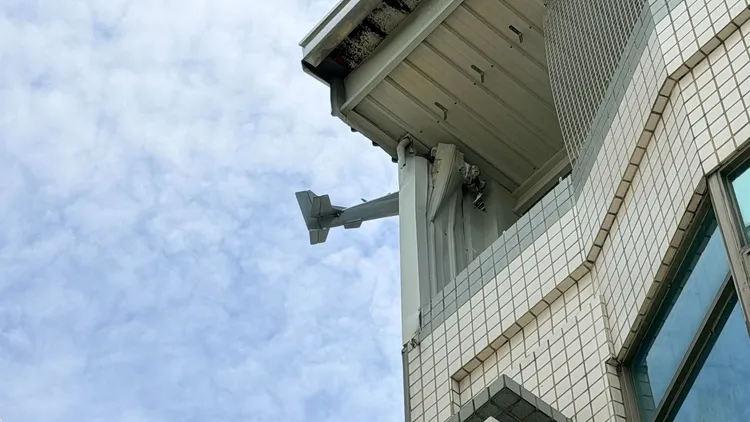 搖控無人機撞進民宅卡在遮陽棚上，機尾露在外面。民眾提供