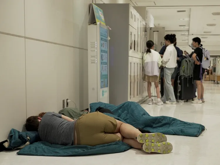 受困在成田機場的旅客席地而睡。路透社