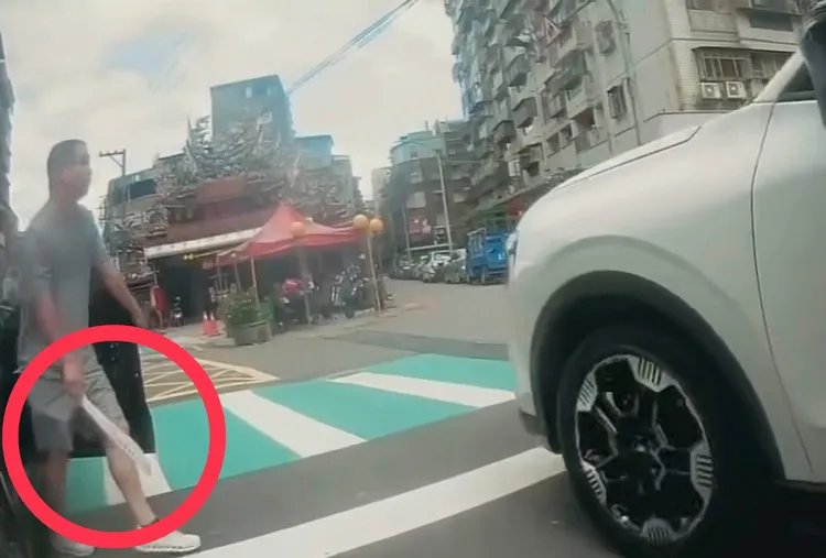副駕駛男子手持開山刀怒氣沖沖下車，急找按喇叭騎士算帳，嚇壞一旁用路人。翻攝自Threads@ziran7995