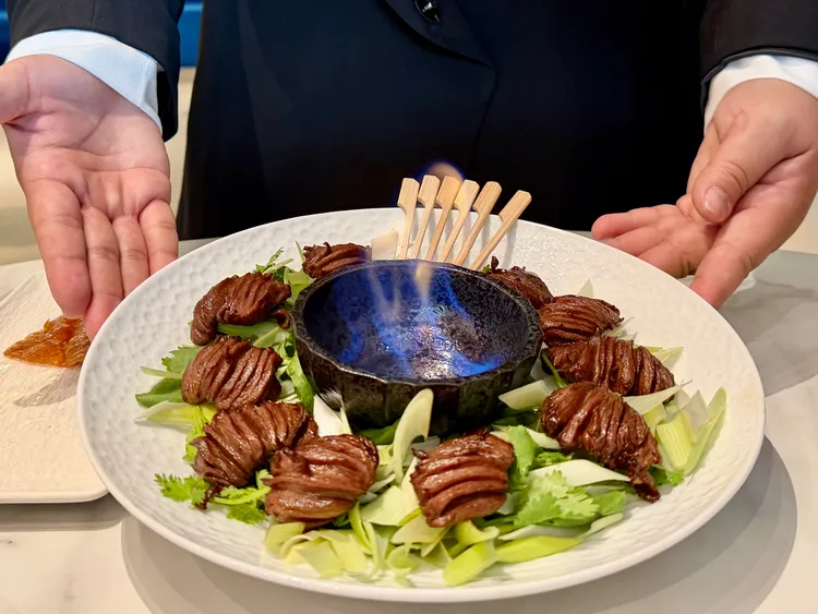 首賣餐點「火燎鴨心」，上桌時搭配燃燒的高粱酒火焰秀。莊偉祺攝