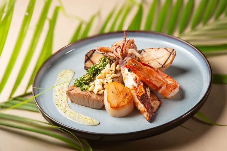 台北萬豪Garden Kitchen「鮪大航道・豪享海味」，主餐推薦「碳烤鮪魚中脂綜合海鮮盤襯酒粕奶油醬」每份2180元+10%，選用油脂豐潤的鮪魚中腹，搭配東北角海蝦、北海道生食級干貝、澎湖小卷。業者提供