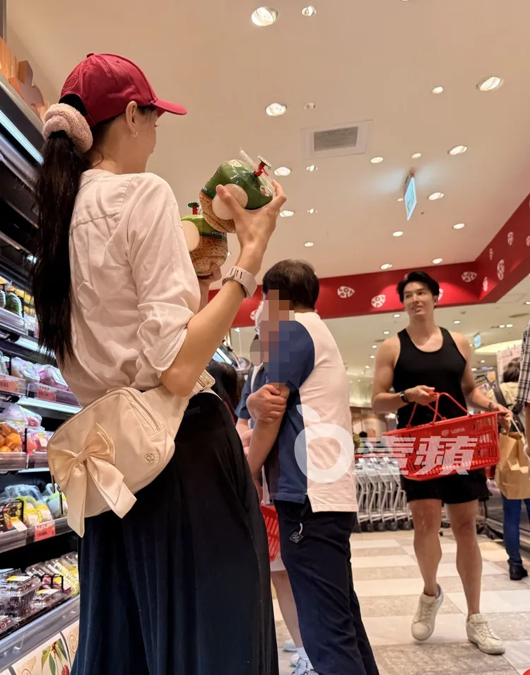 白彌兒挑選椰子水，錦榮提著購物籃走過來會合。讀者提供