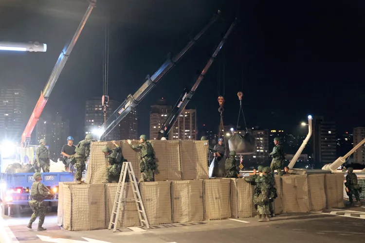 國軍今年把新落成的淡江大橋納入漢光演習範圍。國軍工兵現場架設艾斯科防爆牆 。李俊毅攝影