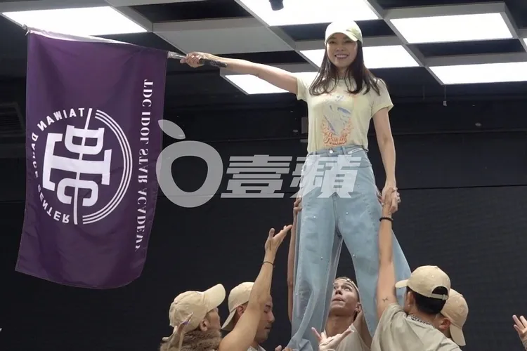曾馨瑩被舞群舉起，高舉大旗展露笑容。特勤中心攝