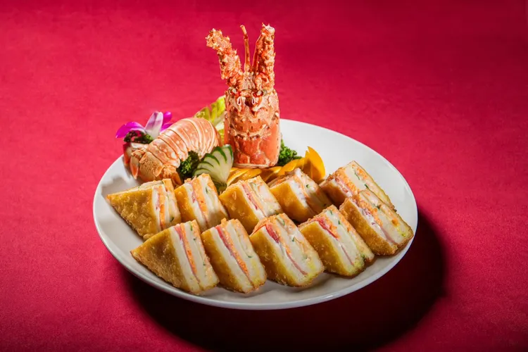 台北凱達大飯店「呷辦桌」經典臺菜宴中的「龍蝦三明治」，以酥脆吐司包裹鮮美龍蝦餡，外酥內鮮，重現臺灣辦桌宴席中令人懷念的經典滋味。台北凱達大飯店提供