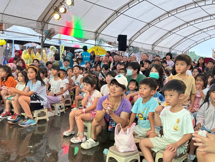 大小朋友聚精會神及吃著「台電」贈送冰棒專心看劇。公所提供