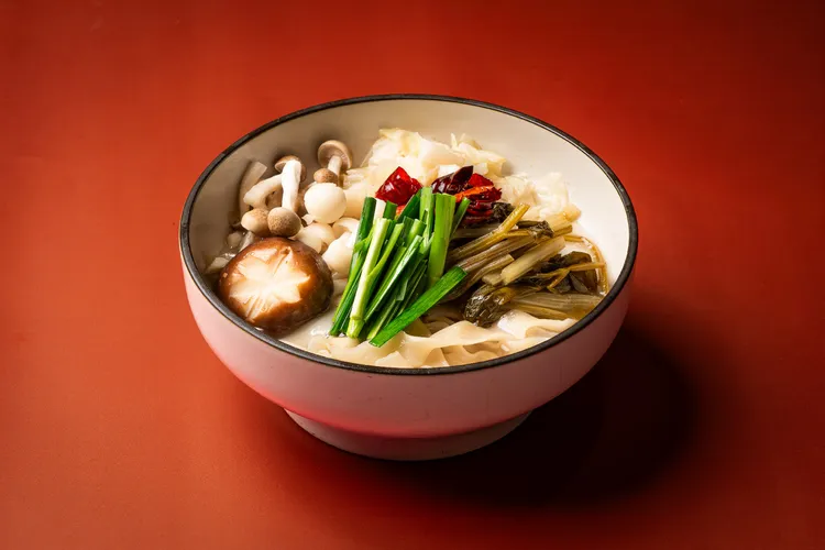 「秦香野菌漿水麵」以陝西傳統「漿水」為風味基底，將芹菜、高麗菜汆燙後加入麵湯發酵，形成自然微酸的清爽滋味，搭配野菌香氣，呈現不同於一般中式湯麵的風味層次。板橋凱撒大飯店提供