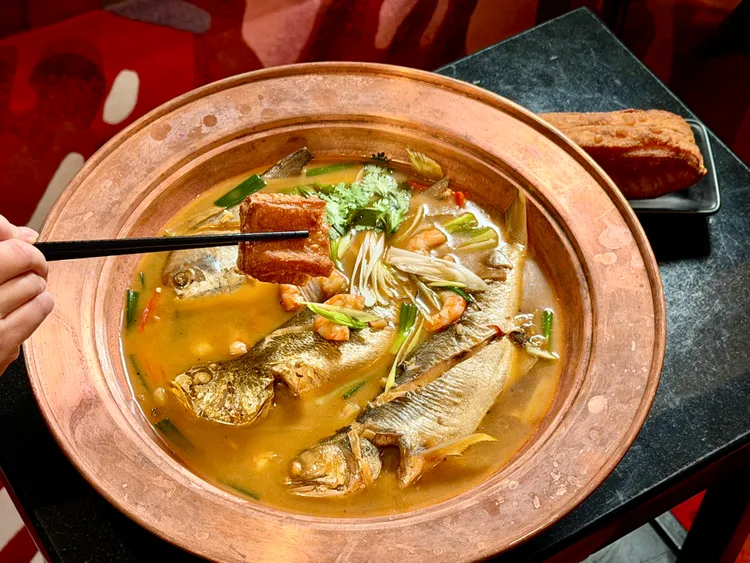台北店限定「福園半煎煮」以整尾煎魚燉煮海鮮鍋，搭配帶有甜甜圈口感的巨型油條。莊偉祺攝
