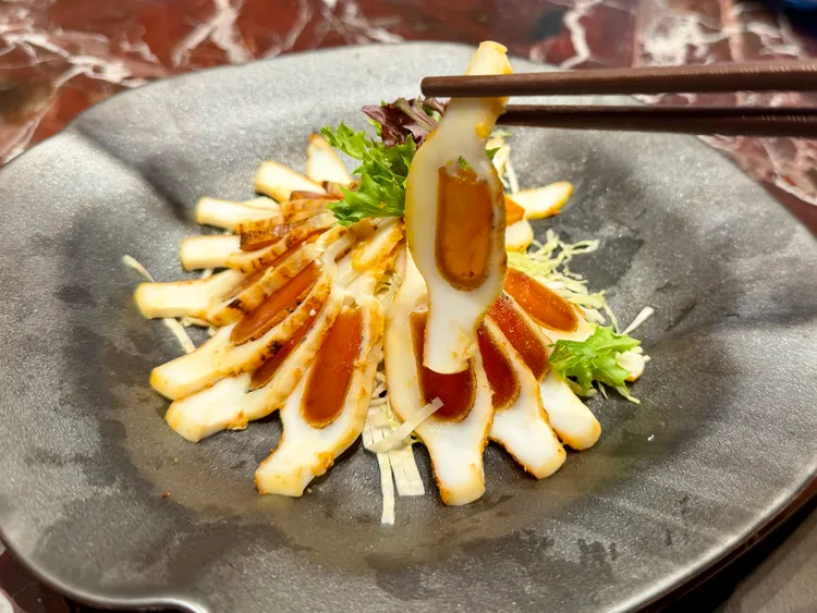 將炙烤烏魚子嵌入軟絲中薄切的刀工菜「烏金釀軟絲」。莊偉祺攝