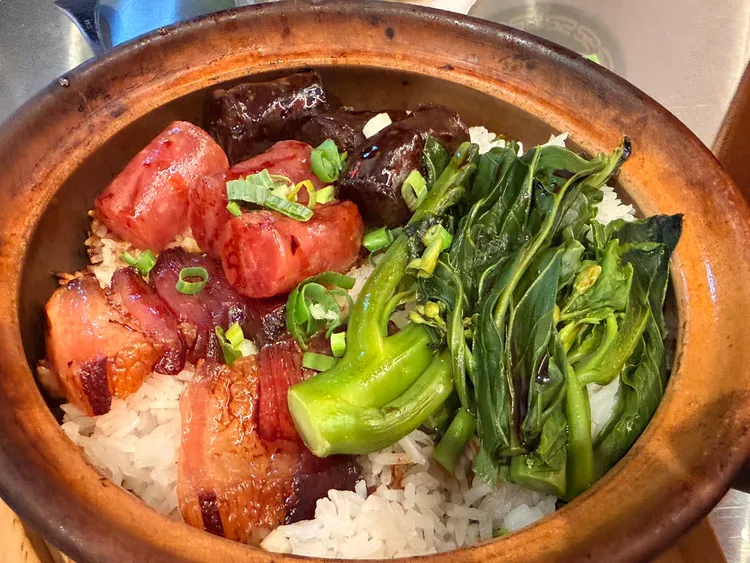 廣式臘味煲仔飯現點現煲，厚切臘腸、肝腸與臘肉鋪滿米飯，高溫煲製逼出臘味油脂與醇郁酒香，底部焦香爽脆的金黃鍋巴更是整鍋亮點。陳揚盛攝