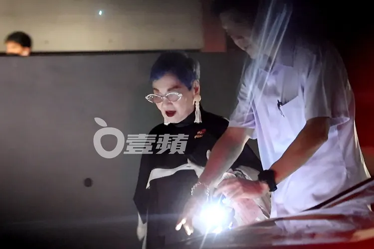 張小燕就著接待人員手電筒燈光下階梯，搭乘自家BMW轎車離開。特勤中心攝