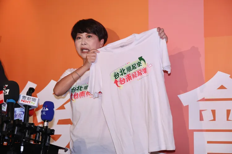 台南市長參選人陳亭妃拿出印有「台北順起來、台南妃起來」的上衣。莊宗達攝
