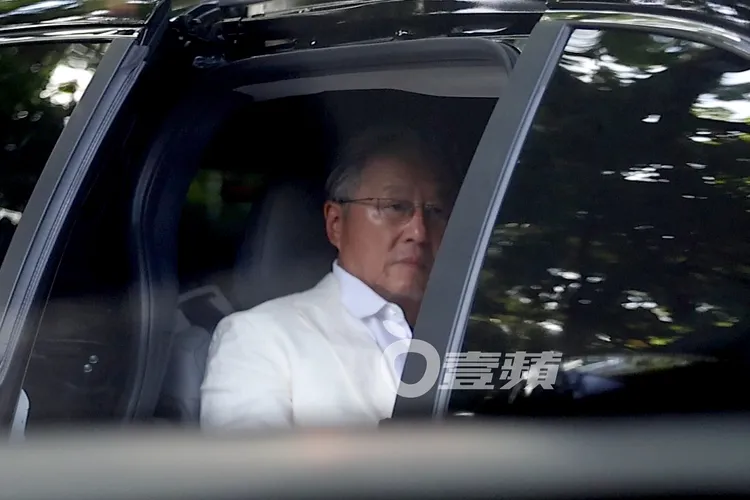 穿著白西裝的王偉忠準備下車。特勤中心攝
